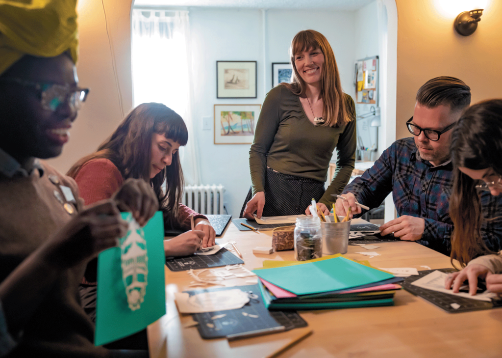 Justin Tsucalas Annie Howe, studio owner, smiles at participants of her paper cutting workshop.
